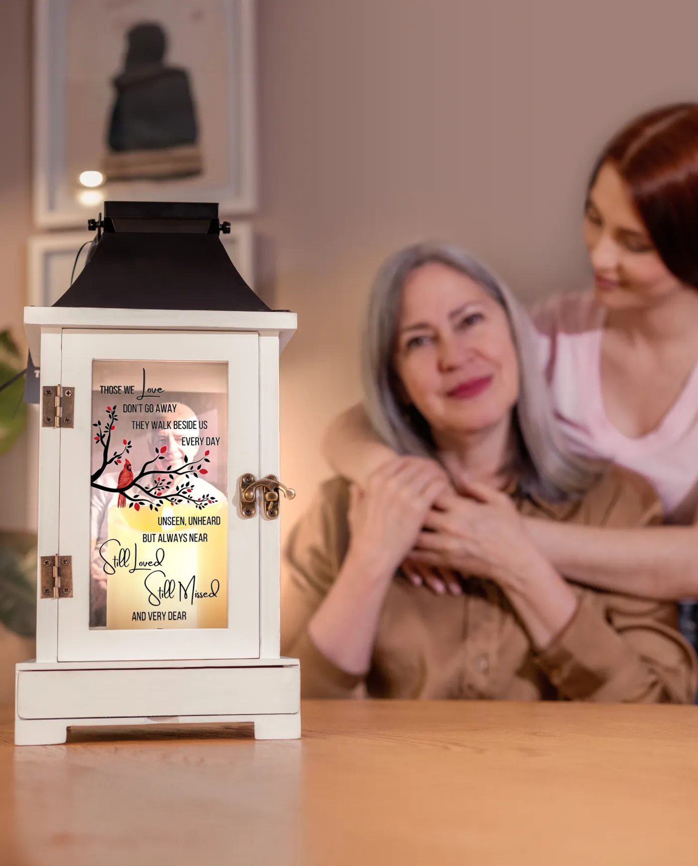 A lit wood lantern with a black crown beside a mother and daughter