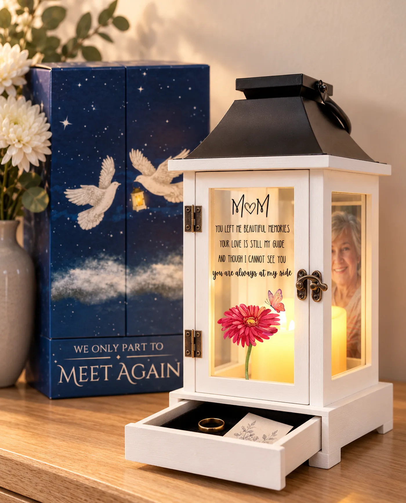 The wood lantern with a black crown, lit, its drawer open and a photograph behind the glass, beside its gift box